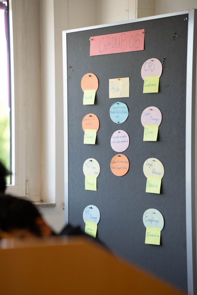 Photo of a bulletin board with colorful sticky notes in an office setting.